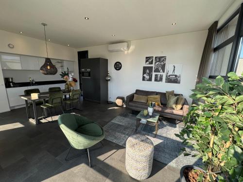 a living room with a couch and chairs and a table at Enkhuizer Strand Chalet WellenZeit Haus Nr 260 in Enkhuizen