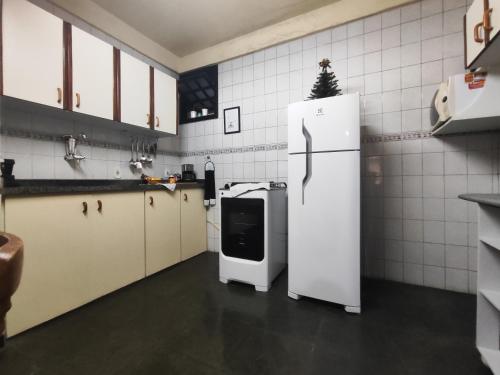 cocina con nevera blanca en una habitación en Apartamento no bairro Quitandinha - Petrópolis RJ, en Petrópolis