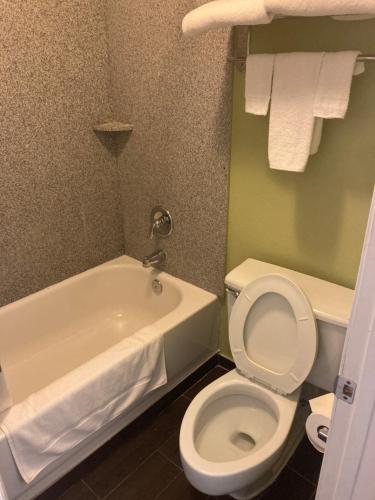 a bathroom with a white toilet and a bath tub at Suite With Pool Access in Davenport