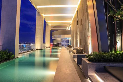 a hotel swimming pool in a building at night at Super Luxury Designer Sleeps 6 People in Thonglor in Bangkok