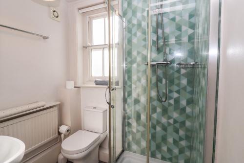 a bathroom with a toilet and a glass shower at Eldoret in Aldeburgh