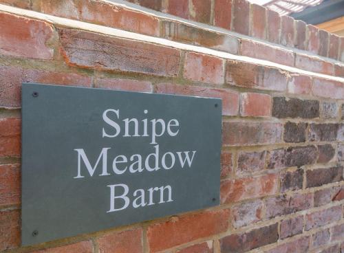 a sign on the side of a brick wall at Snipe Meadow Barn by Big Skies Estates in Swafield