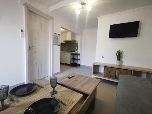 a living room with a table and a tv on the wall at Anthis Studios in Pythagoreio