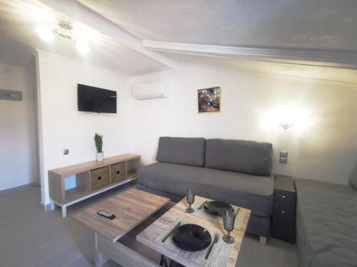 a living room with a couch and a table at Anthis Studios in Pythagoreio