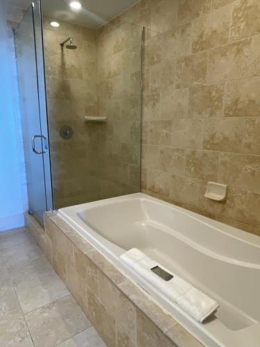 a bathroom with a bath tub and a shower at South Beach Biloxi Hotel & Suites in Biloxi