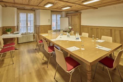 a conference room with a large wooden table and chairs at Baeren Hotel, The Bear Inn in Wilderswil