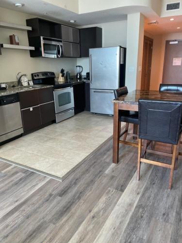 a kitchen with a refrigerator and a wooden table at South Beach Biloxi Hotel & Suites in Biloxi
