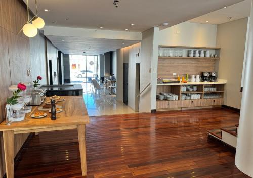 a kitchen and living room with a wooden floor and a table at Roomie Salta by DOT Suites in Salta