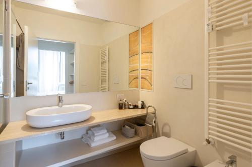 a bathroom with a sink and a toilet and a mirror at Heart Milan Apartments San Sepolcro Duomo in Milan