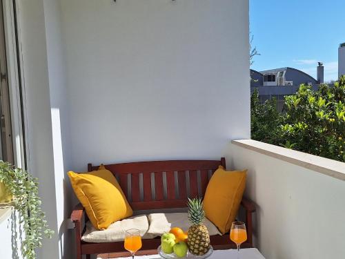 un banco en un balcón con 2 vasos de zumo de naranja en Apartment Leona, en Split