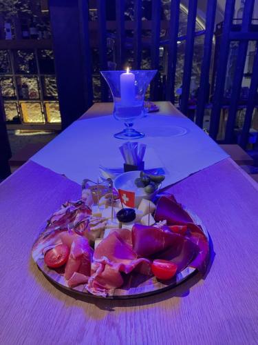 a plate of food on a table with a candle at Baeren Hotel, The Bear Inn in Wilderswil