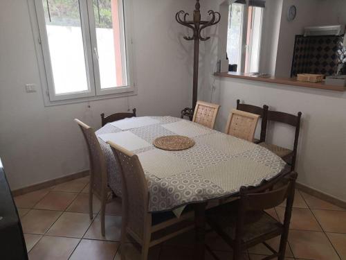 - une table à manger avec des chaises, une table blanche, une table et des chaises dans l'établissement Appartement 20m de la plage, à Cerbère