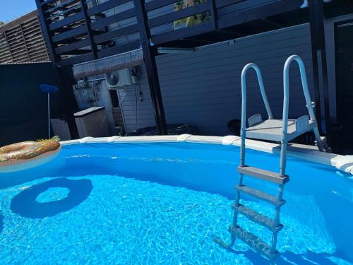 a swimming pool with a chair in the water at Ti Kaz Fond de Puits in Saint-Philippe
