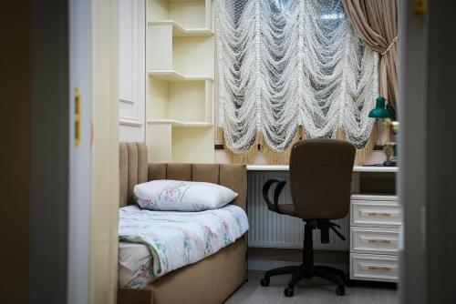 a bedroom with a desk and a chair and a window at Learmara Apartment #2 in Samarkand