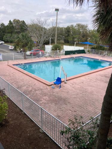a swimming pool with a chair in front of a fence at Suite With Pool Access in Davenport