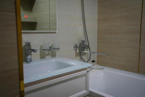 a bath tub in a bathroom with a shower at Learmara Apartment #2 in Samarkand