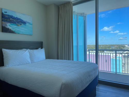 a bedroom with a bed and a large window at South Beach Biloxi Hotel & Suites in Biloxi