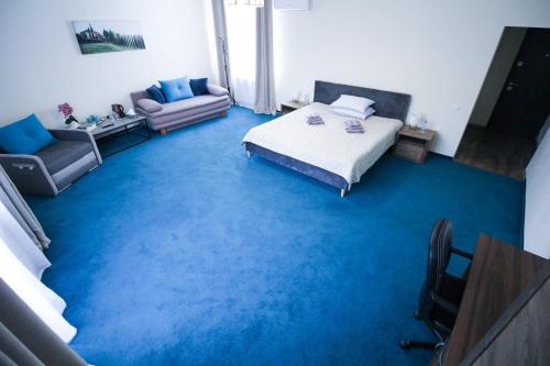 a room with a bed and a blue carpet at Zara Apartament 1 in Târgu-Mureş
