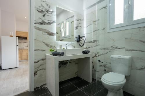 bagno con servizi igienici, lavandino e specchio di Paradiso Aparthotel a Ipsos