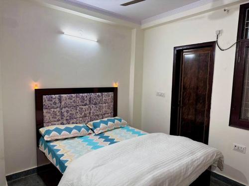 Un pat sau paturi într-o cameră la Modern 2bhk near Delhi Airports by Nirvana villa Apartments