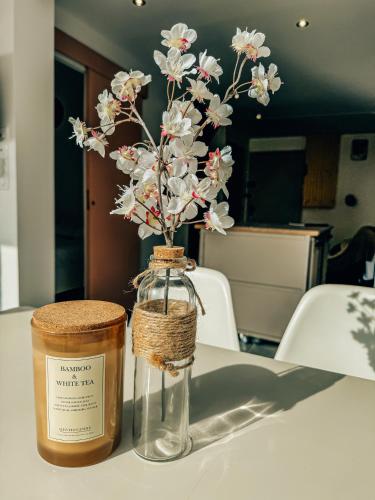 a jar with flowers in it sitting on a table at BEACH HOUSE 100M PLAGE, SUR LE PORT. in Frontignan