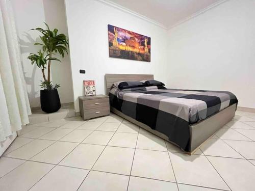 ein Schlafzimmer mit einem Bett und einer Topfpflanze in der Unterkunft Casa Vacanza Fiera di Roma in Ponte Galeria