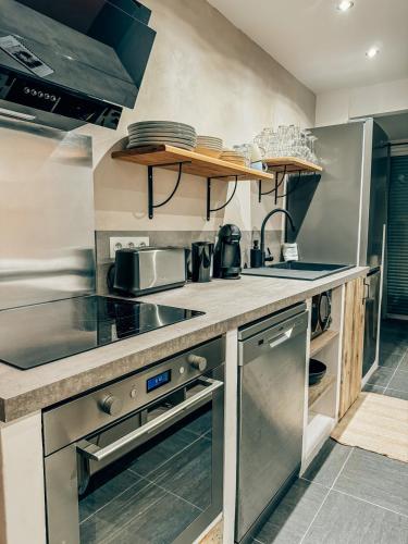 a kitchen with stainless steel appliances and counters at BEACH HOUSE 100M PLAGE, SUR LE PORT. in Frontignan