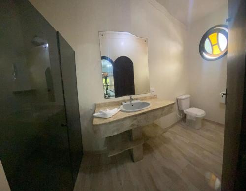 a bathroom with a sink and a toilet and a mirror at Pousada Estrela Dalva in Penha