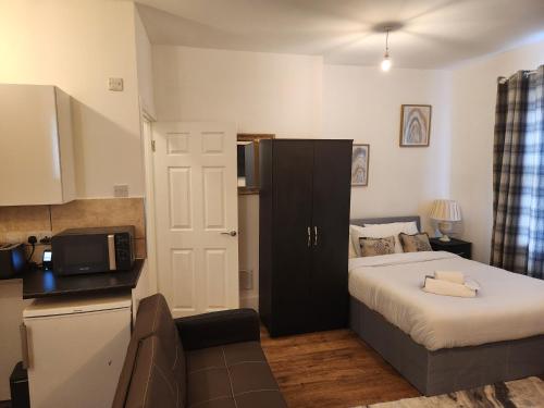 a small bedroom with a bed and a microwave at 1 Bed Flat - Sleeps 3 - Parking - Wifi in Greenhithe