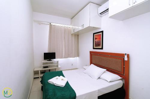 Dormitorio pequeño con cama y TV en Belo 2 quartos para 6 pessoas na quadra da praia, en Río de Janeiro