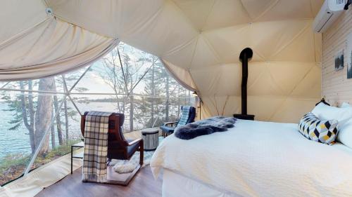 1 dormitorio con cama y vistas al agua en White Point Beach Resort en Summerville Centre