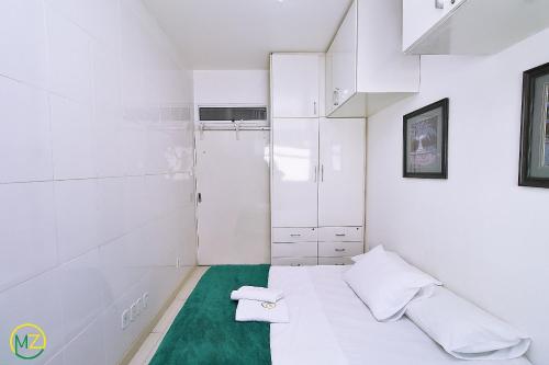 Habitación blanca pequeña con cama y bañera en Belo 2 quartos para 6 pessoas na quadra da praia, en Río de Janeiro
