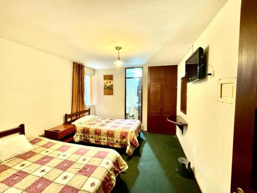 een hotelkamer met 2 bedden en een flatscreen-tv bij Hotel Los Angeles in Arequipa