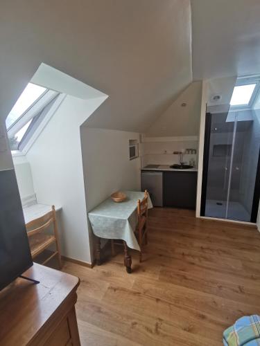 an attic room with a table and a kitchen at Chopin in Les Haies