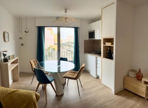 une cuisine et une salle à manger avec une table et des chaises dans l'établissement Joli appart proche plage du môle et flânerie, au Cap d'Agde