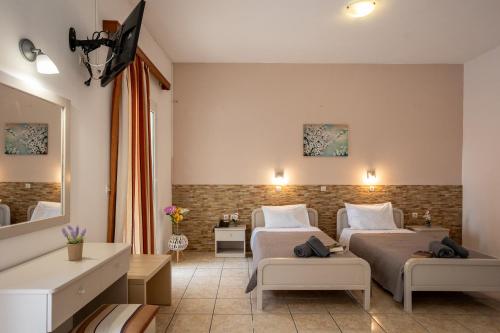 een hotelkamer met 2 bedden en een spiegel bij Paradiso Aparthotel in Ýpsos
