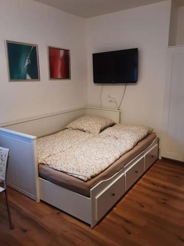 雷根斯堡的住宿－Alfred Second，卧室配有一张壁挂式平面电视的床。