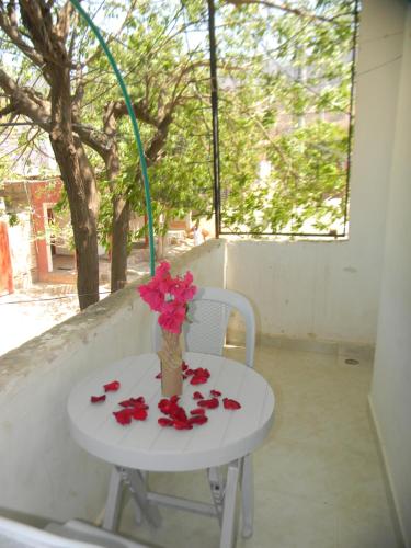 un tavolo con un vaso di fiori sopra di HostalNativo a Taganga