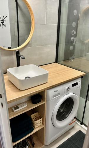 une salle de bain avec un lavabo et une machine à laver dans l'établissement Joli appart proche plage du môle et flânerie, au Cap d'Agde