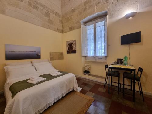 Schlafzimmer mit einem Bett, einem Tisch und einem Fenster in der Unterkunft LA VOLTA in Lecce