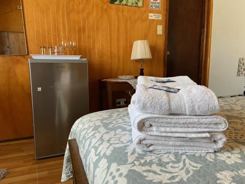a pile of towels sitting on top of a bed at Hotel Cabañas Caribe in Los Vilos