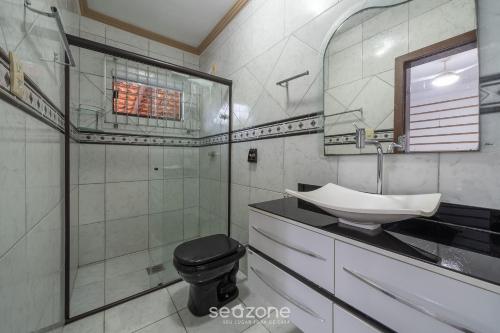 La salle de bains est pourvue d'un lavabo, de toilettes et d'une douche. dans l'établissement Casa 3 quartos a 50m da praia Penha-SC EPS055, à Penha