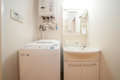 a small bathroom with a sink and a refrigerator at Liberte Nakajima Park Room 201,302 - Vacation STAY 98202v in Sapporo