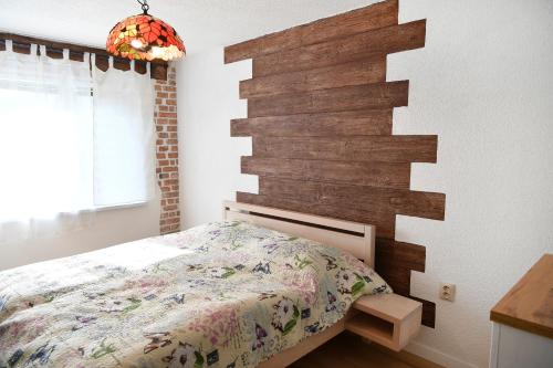 ein Schlafzimmer mit einem Bett und einer Holzwand in der Unterkunft APARTMAN Tradicia in Michalovce