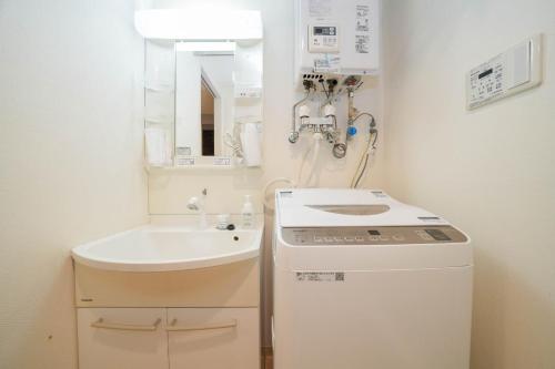 baño pequeño con lavabo y lavadora en Liberte Nakajima Park Room 201,302 - Vacation STAY 98216v en Sapporo