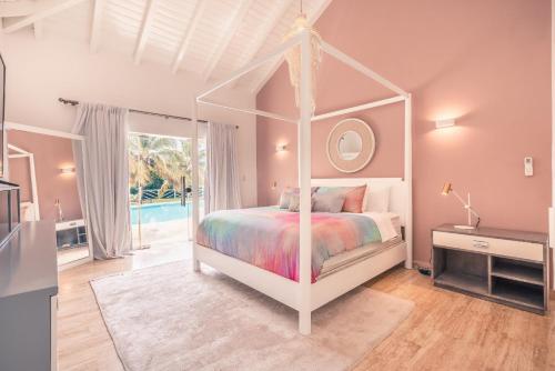 a bedroom with a white canopy bed with a mirror at 4BR Villa w private pool at Lagunas Cap Cana in Punta Cana