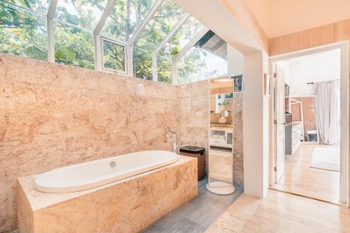 a large bathroom with a tub and a window at 4BR Villa w private pool at Lagunas Cap Cana in Punta Cana