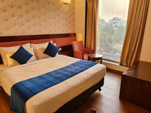 新德里的住宿－RoseMallow Tavisha Hotel，一间设有大床和窗户的酒店客房