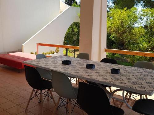 une table et des chaises assises sur une terrasse avec une fenêtre dans l'établissement VILLA LUCIA, à Matino