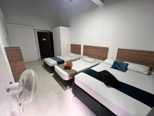 a hotel room with two beds and a fan at 7 Express in Medellín